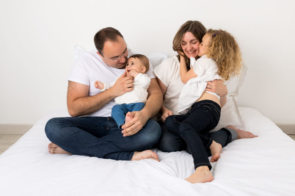 Séance photo cocooning maman papa bébé enfant sur un lit comme à la maison, dans les Yvelines 78